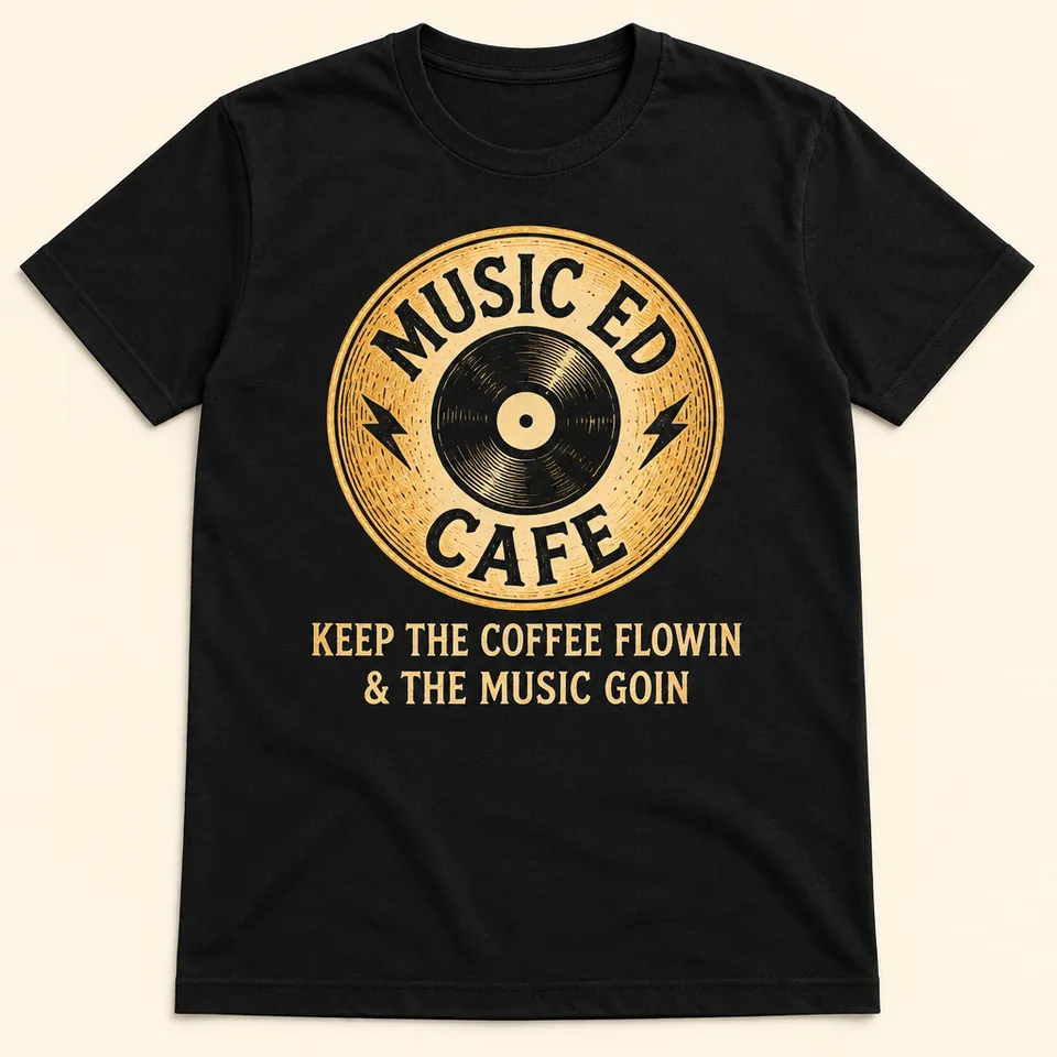Mockup of a black t-shirt printed with the gold Music Ed Cafe record badge and the words Keep the Coffee Flowin and the Music Goin